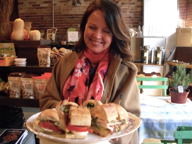 Salem Food Tour guide holding up platter of fresh, thick sandwiches
