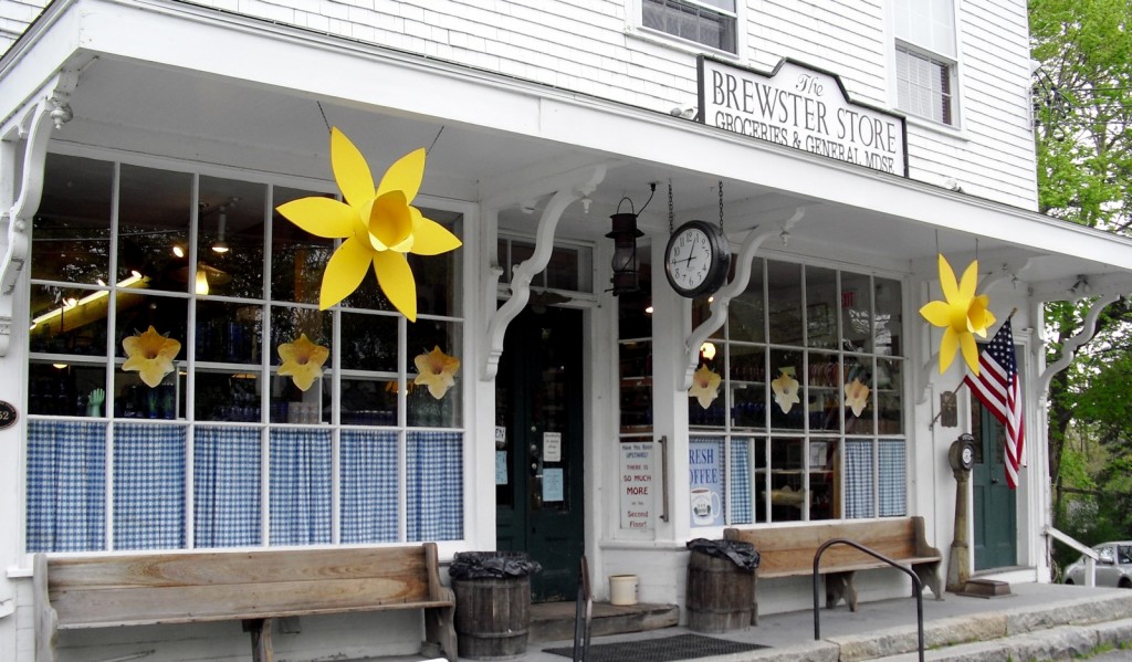 Large plastic lilies and inviting benches at entrance to a Cape Cod General Store
