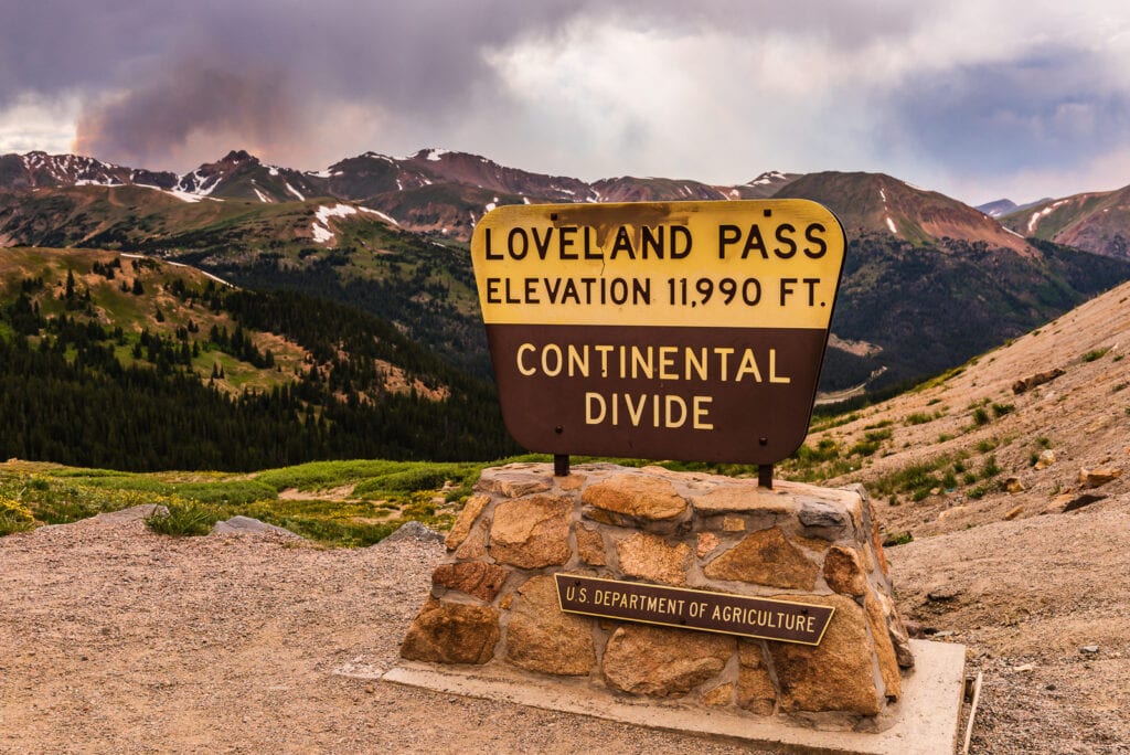 Sign at Loveland Pass on the Continental Divide with Rocky Mountains in the background.