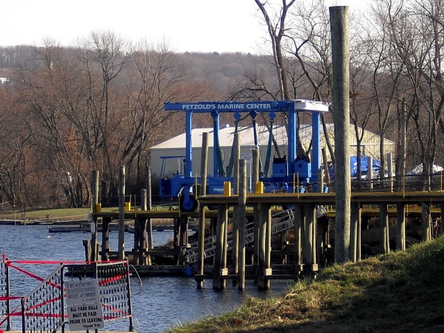 Blue travelift set against a stark winter Connecticut River scene. Petzolds Marine Center, Portland, CT