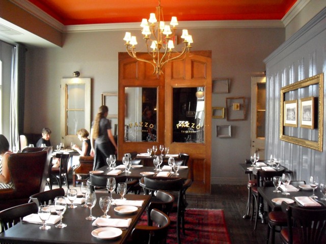 Interior of upscale restaurant with candle-lamp chandelier and mirror armoire 