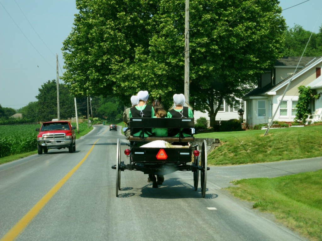 Amish girls on buggy heading down two-lane Lancaster PA Amish country road