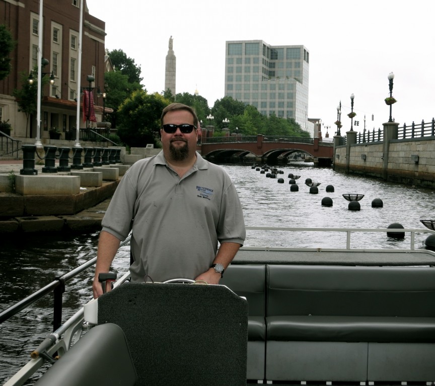 Captain Tom McGinn at the helm of his 28 ft. pontoon river boat, Providence, RI