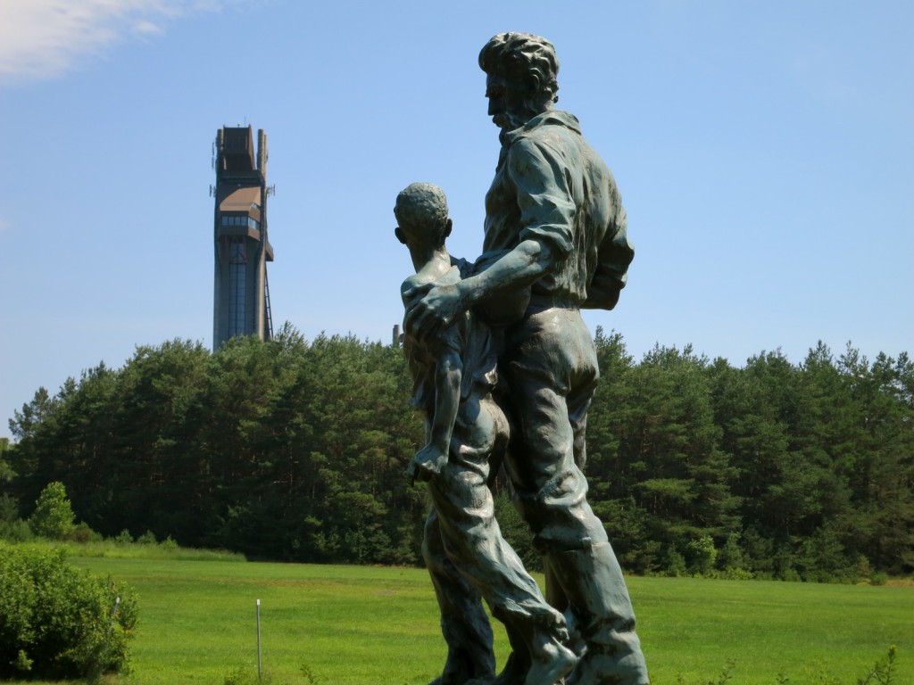 Statue of John Brown with child in shadow of Olympic Ski Jumps, Lake Placid, NY