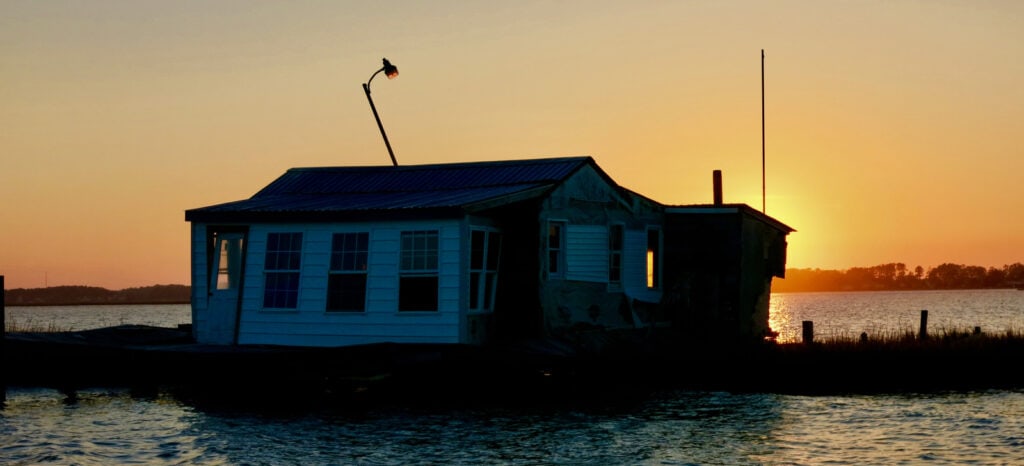 Sun sets behind floating house Captain Dans Boat Tour Chincoteague VA