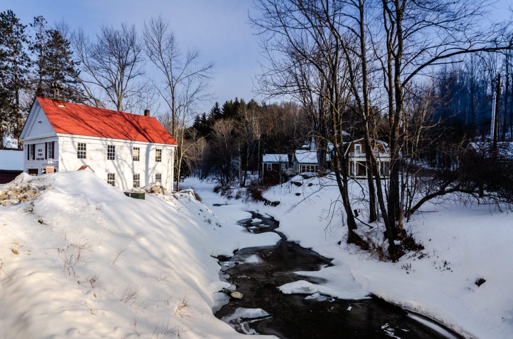 Frozen winter landscape in Grafton, Vermont includes Saxton River creek and the Old Fire Station.
