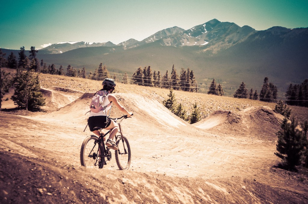 Girl biking on Dirt Jump Facility at Frisco Adventure Park in Frisco, CO.