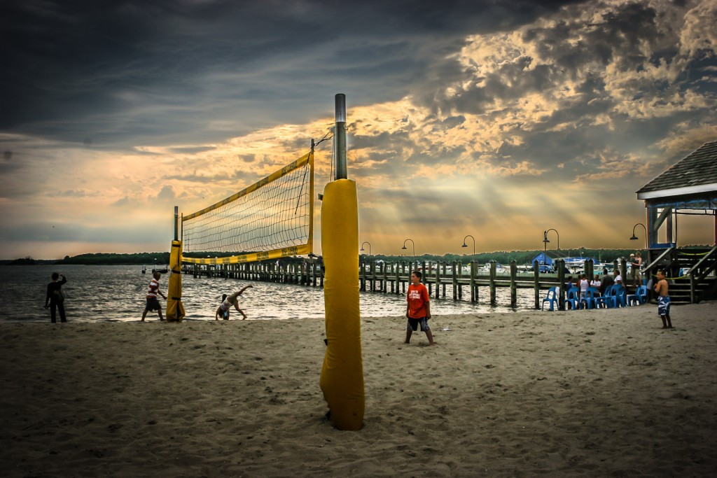 Children playing volleyball, and turning cartwheels, on Dewey Beach near Delaware Seashore State Park.