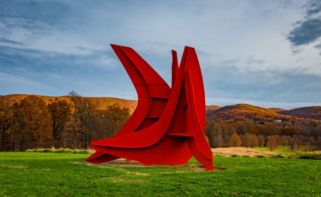 Alexander Calder's Five Swords cuts a crimson slash against the colorful backdrop of peak fall foliage in the Hudson Highlands .