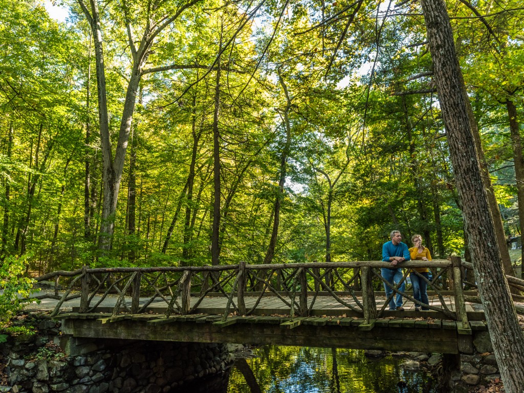 Couple leans over Headless Horseman Bridge at Sleepy Hollow Cemetery