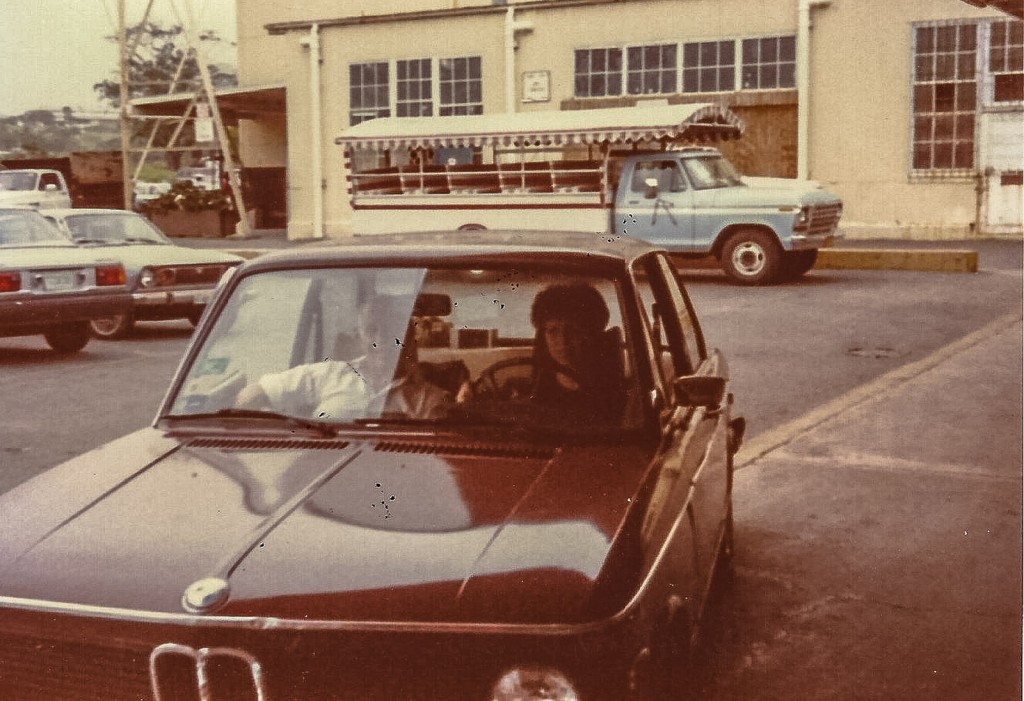 Sandra Foyt and her grandfather sitting in a Brown BMW.