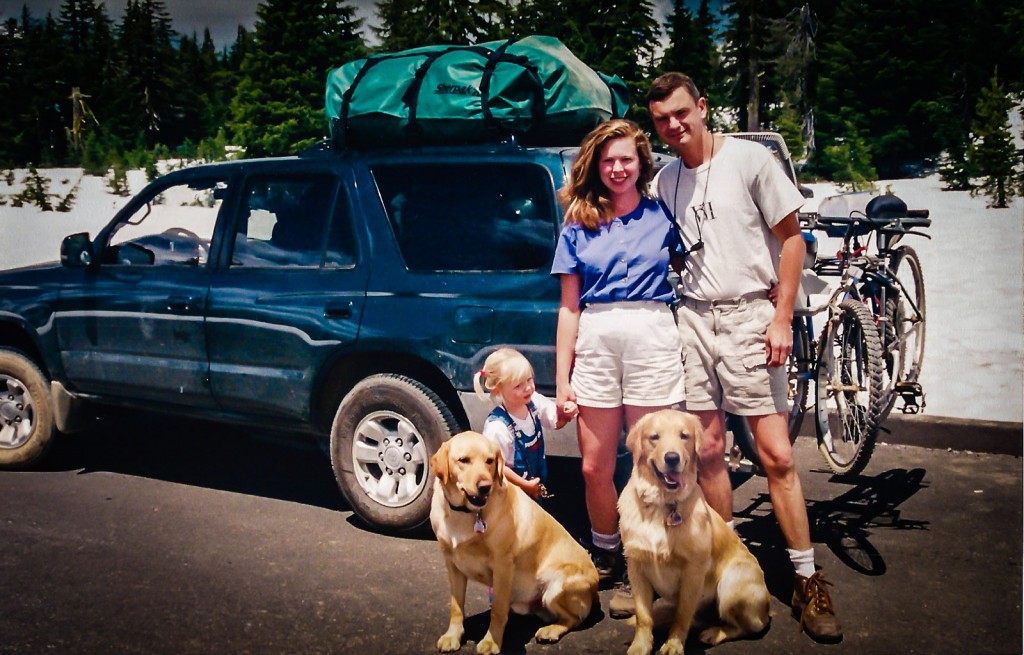 David and Sandra Foyt posing with toddler Kayla and their two retrievers, Mowgli and Spock, in front of their fully loaded Toyata 4Runner.