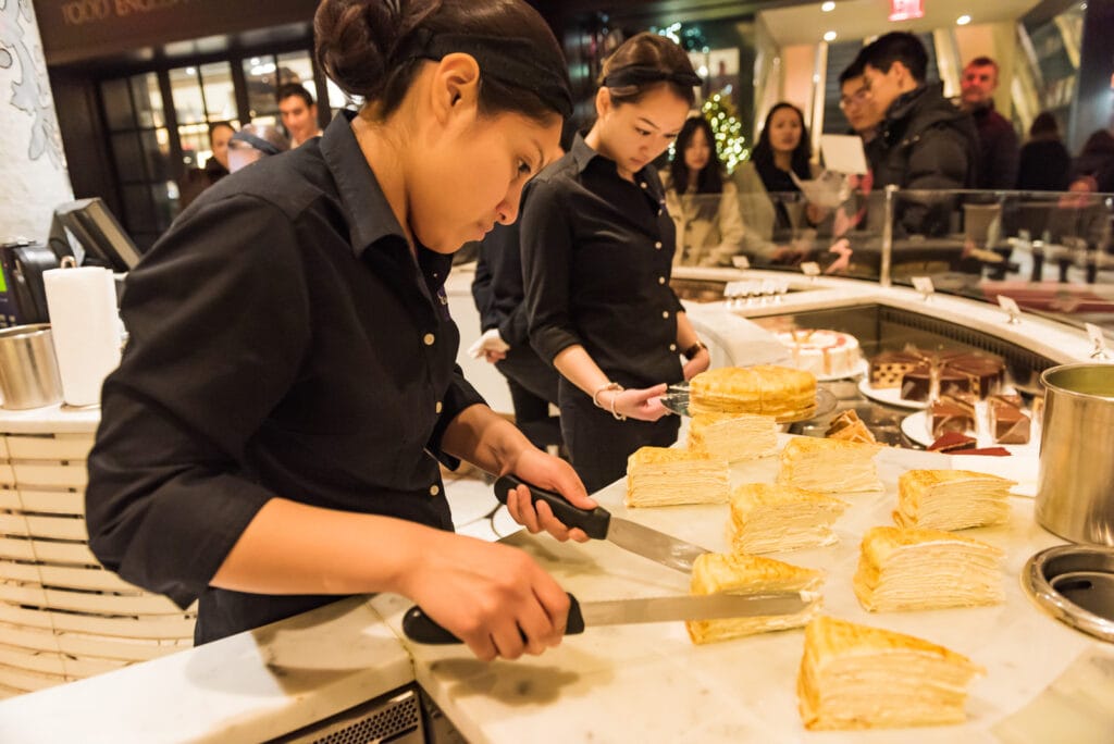 Women serve up Mille Crepe Cake at Plaza Hotel Food Hall.