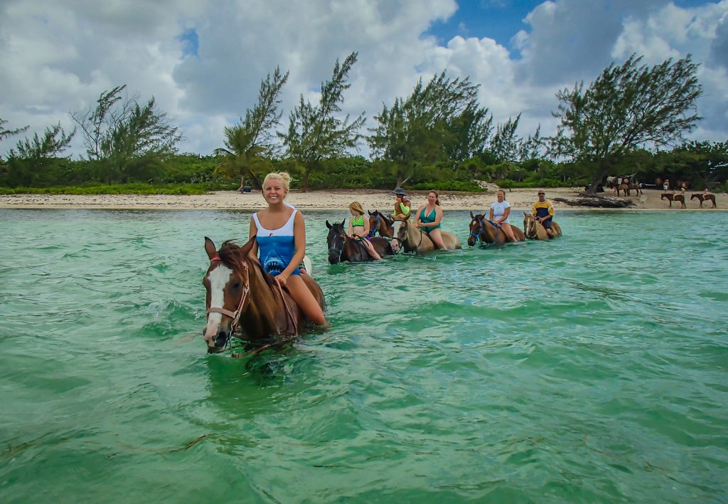 Girl riding horse with tour group in Grand Cayman