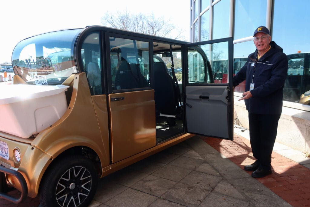 USNA GEM Tour guide, Dave, inviting visitors to his vehicle