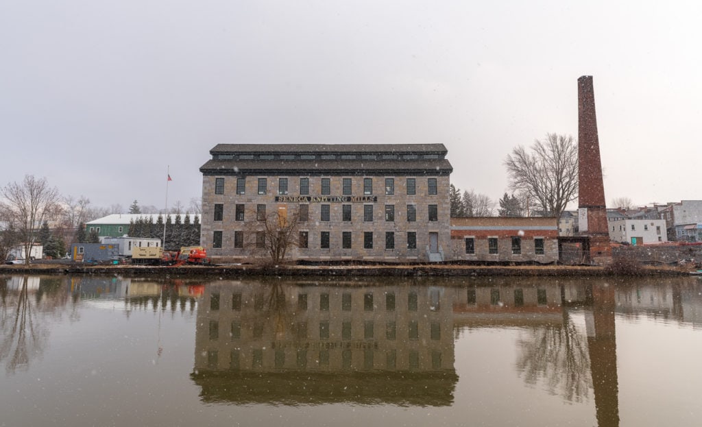 Waterfront view of Seneca Knitting Mill, now The Center for Great Women, during snow shower.