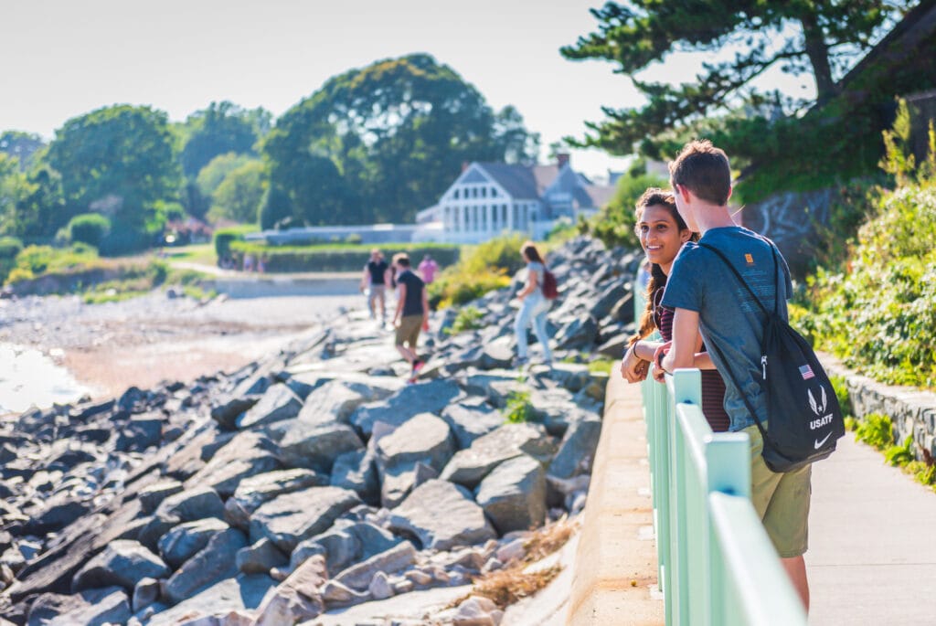 Young couple strolls along the Cliff Walk in Newport, Rhode Island.