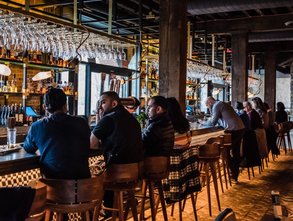 People sitting at the counter. Sugarcane Raw Bar in Brooklyn