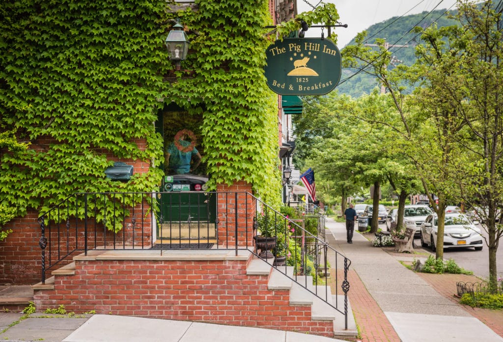 Ivy covered historic building of Pig Hill Inn on street corner in Cold Spring, New York.