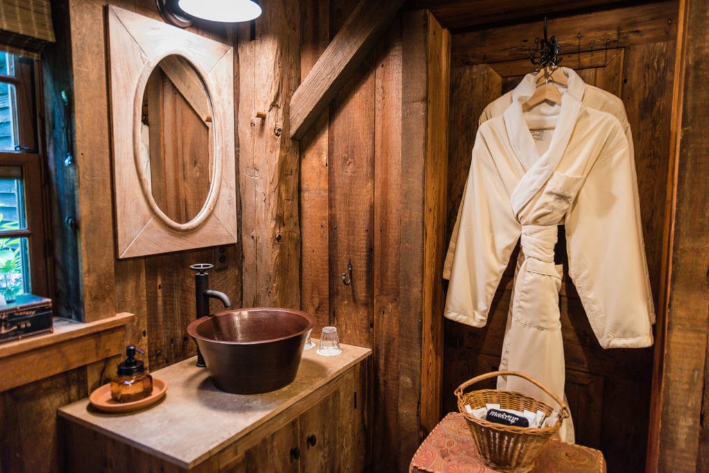 Bathrobes and amenities in rustic bathroom with copper sink at Hudson Valley Rose Bed and Breakfast in Middletown NY.