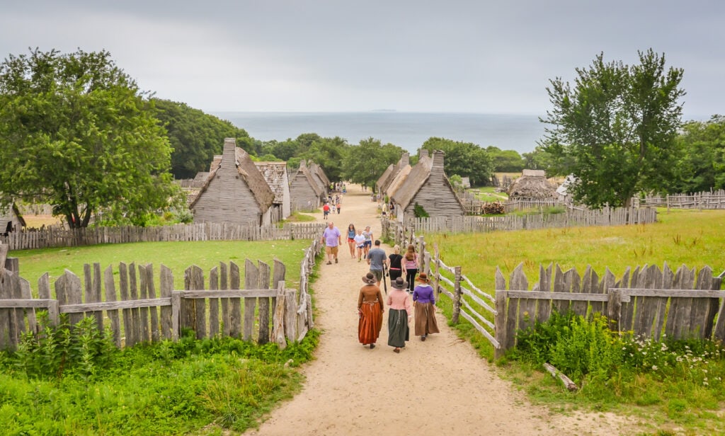 Costumed historic reenactors walk path at Plimoth Plantation.