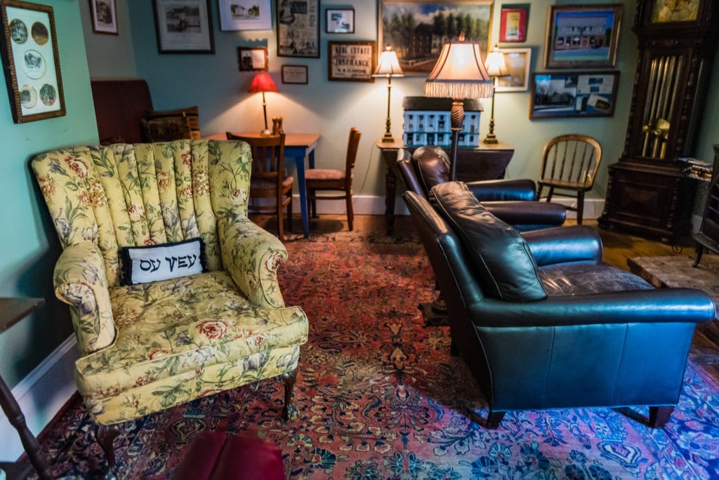 Interior shot of American Hotel lobby with Oy Vey pillow placed on arm chair.