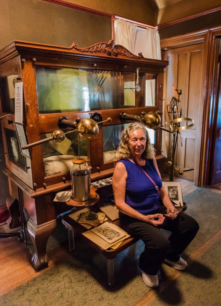 Woman posing with Electrostatic Machine at Dr Best House and Medical Exhibit in Middleburgh NY.