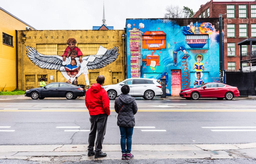 African American couple views mural about education and Black History in Atlanta GA.