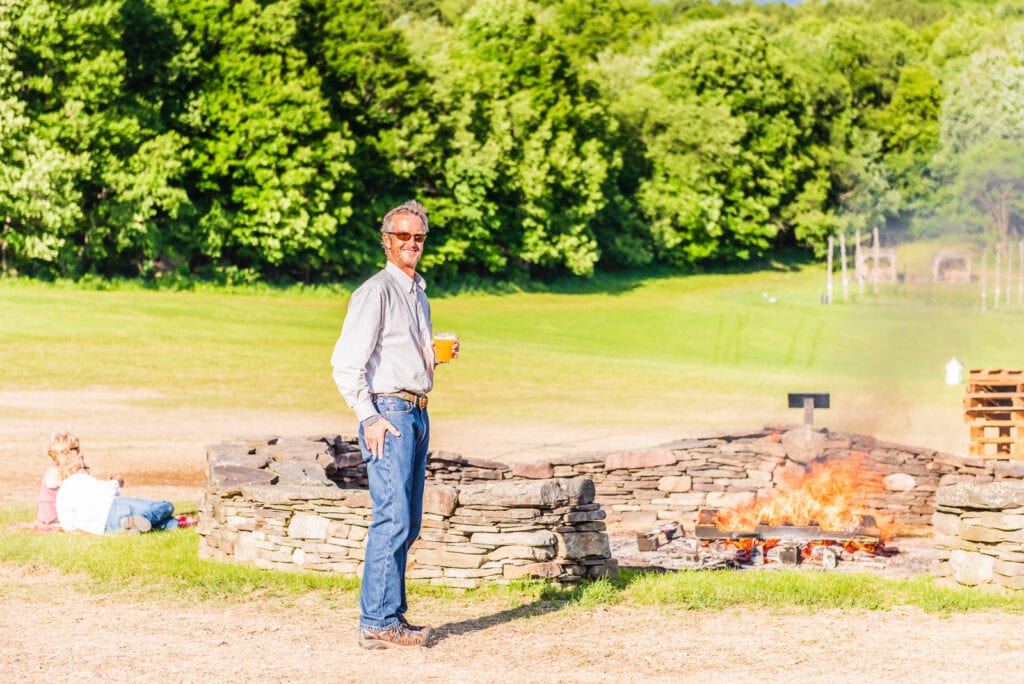 Patron enjoys summer night bonfire at Ommegang Brewery.