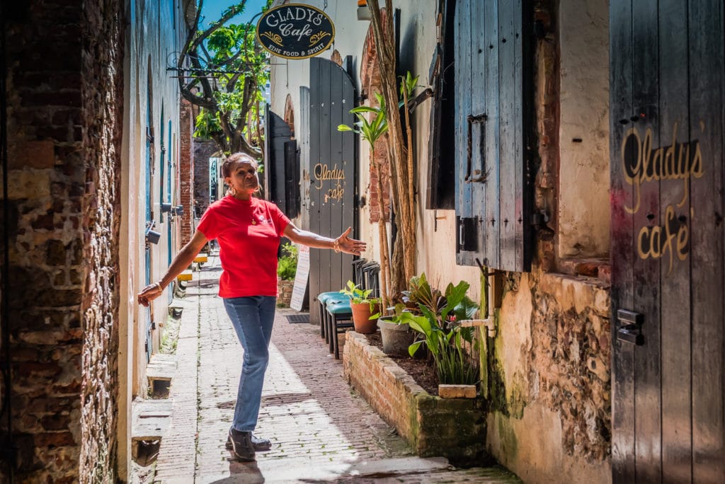 Gladys, owner of Gladys Cafe, poses in the alley where her restaurant is located.