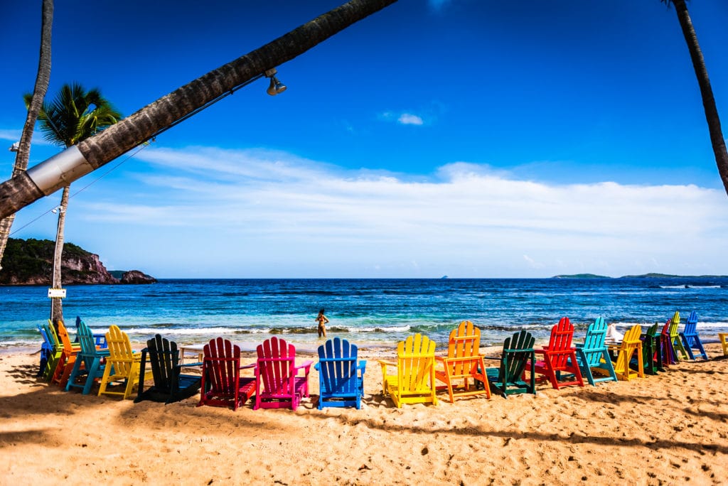 Colorful circle of Adirondack chairs on the beach at Iggies Beach Bar