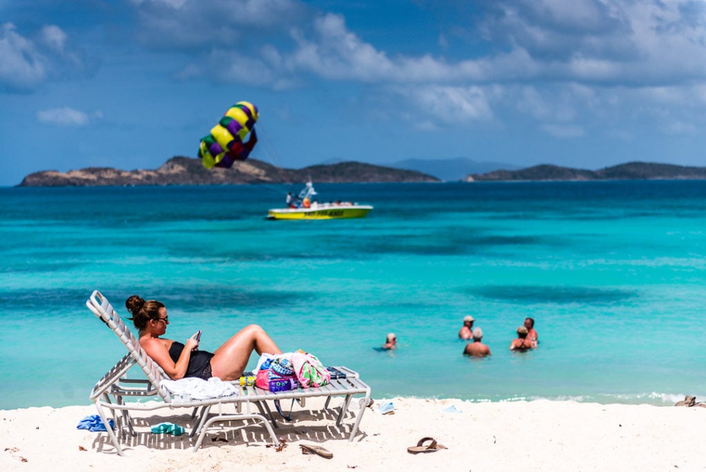 Tourist relaxes on chaise lounge at Saphire Bay. 