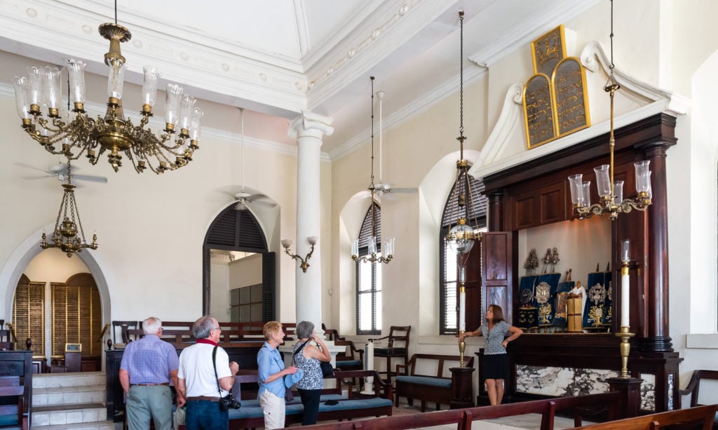 Interior of St. Thomas Synagogue with tourists and sand floor in St. Thomas US Virgin Islands