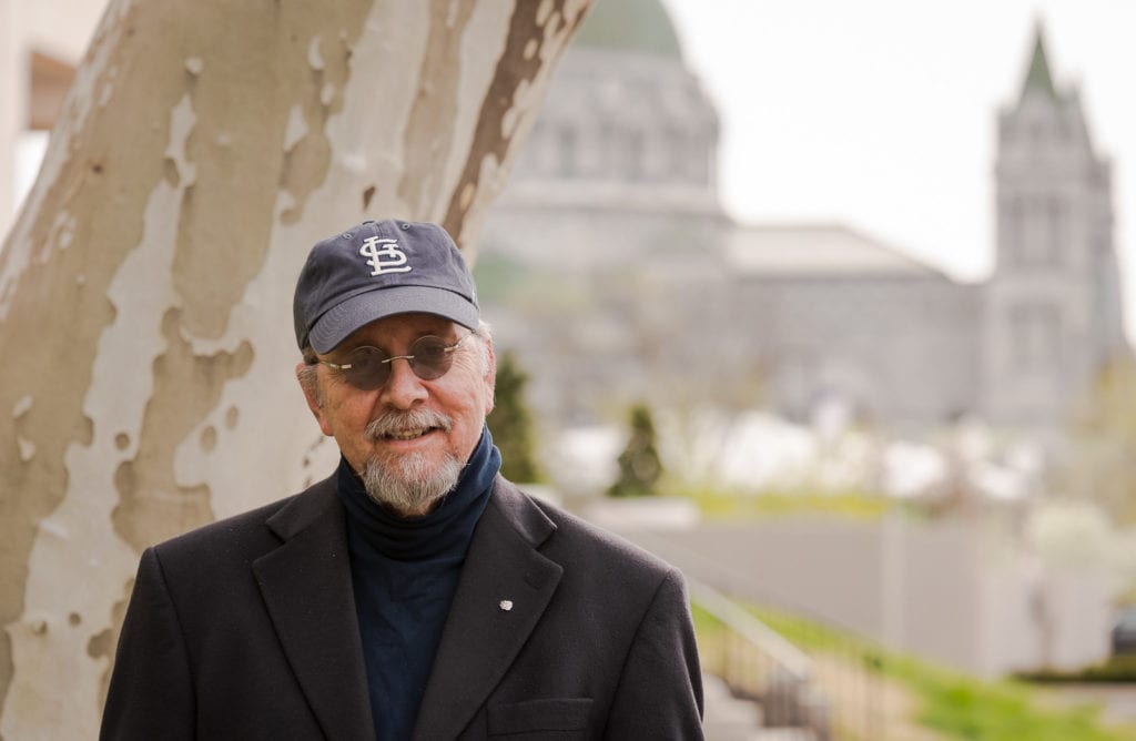 Man wearing St Louis Cardinals baseball cap with Cathedral Basilica in the background.