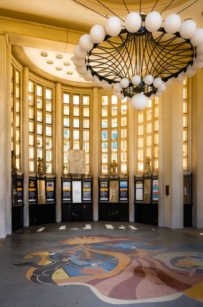 Box office posters under grand interior rotunda at The MUNY.