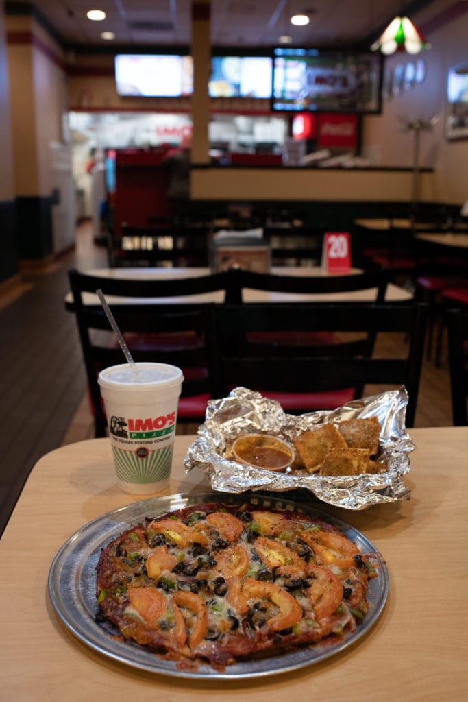 Vegetarian St Louis Style Pizza and Toasted Ravioli set on table at Imos Pizza.