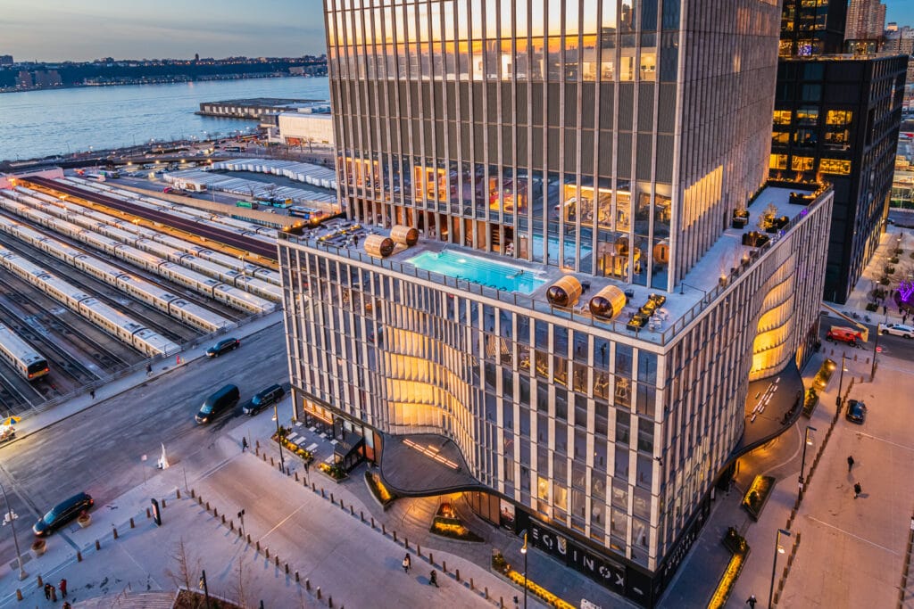 Man watches sunset from Equinox Hotel pool in New York City.