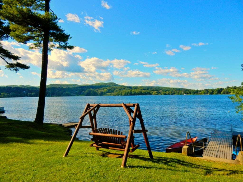 Wooden swing chair view of Lakeville Lake at Interlaken Inn on the Northwest Corner of Connecticut.