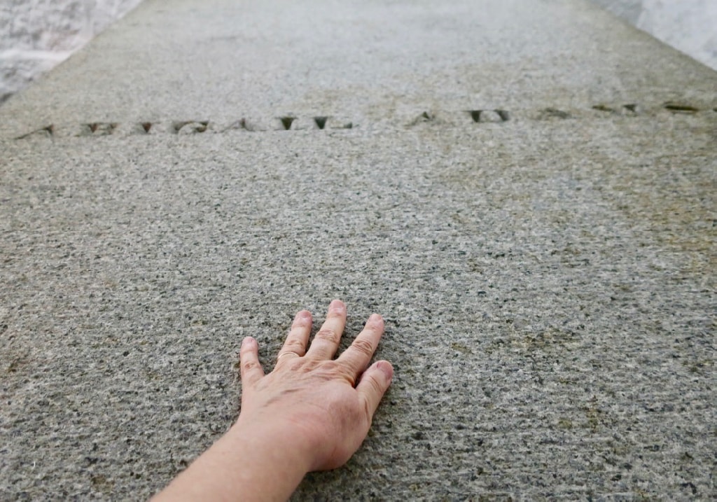 Authors hand on Abigail Adams tomb in Adams crypt Church of the Presidents Quincy MA