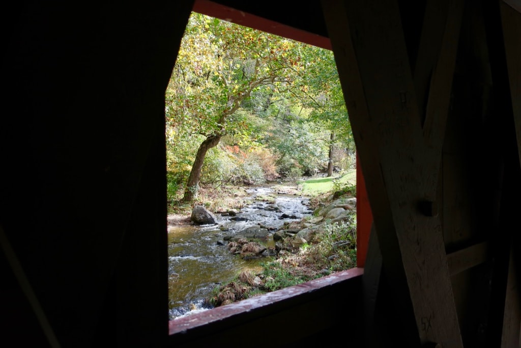 Early fall rocky stream through covered bridge window at Kent Falls SP Connecticut