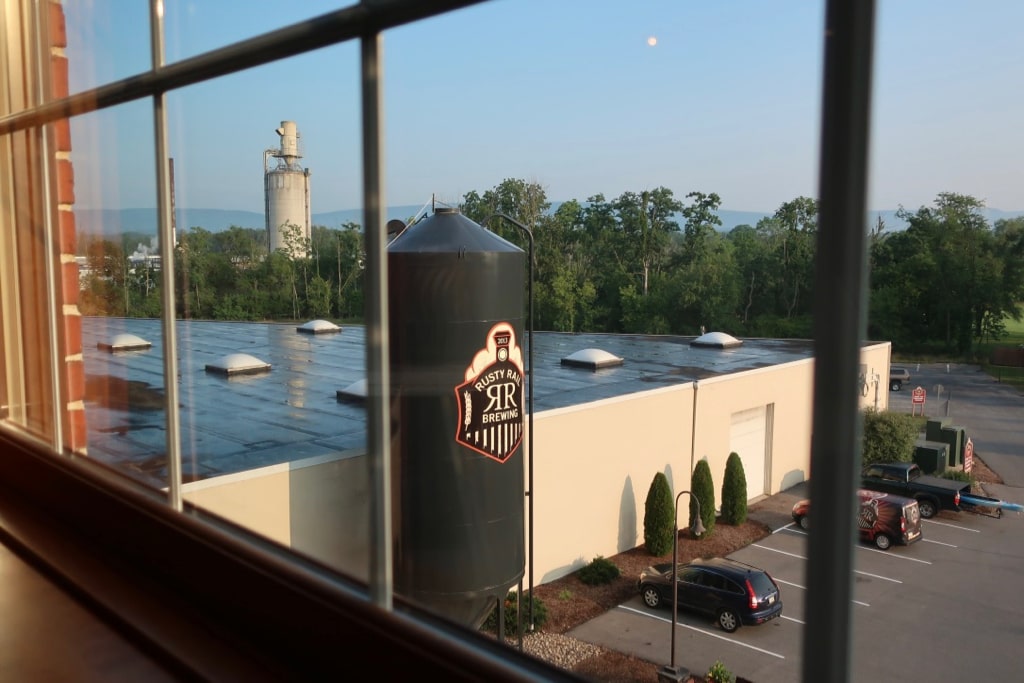 Sunrise over farm and Rusty Rail Brewing tank PA