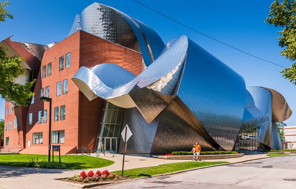 Couple walking past modern building at University Circle in Cleveland Ohio.