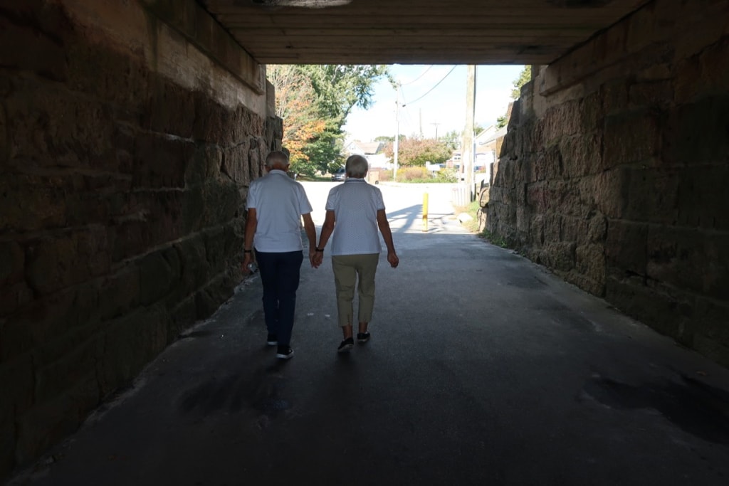 Seniors holding hands in Hole in the Wall Beach tunnel Niantic CT