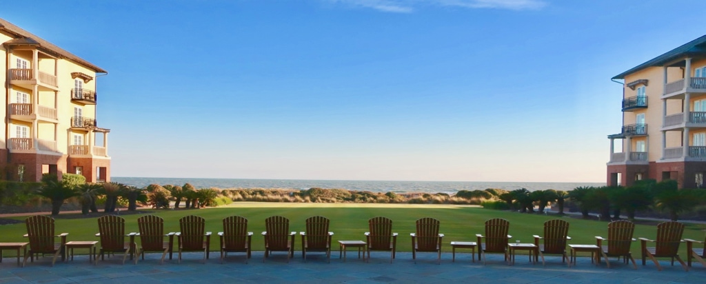 Adirondack chairs face the Atlantic Ocean on the patio of The Sanctuary Resort and Spa SC