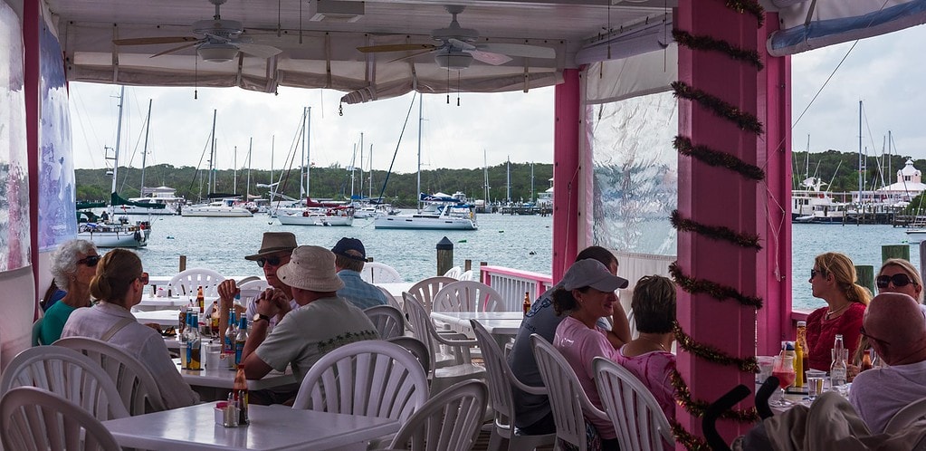 Diners sitting at tables by the ocean at Cap'n Jacks in Hope Town Bahamas