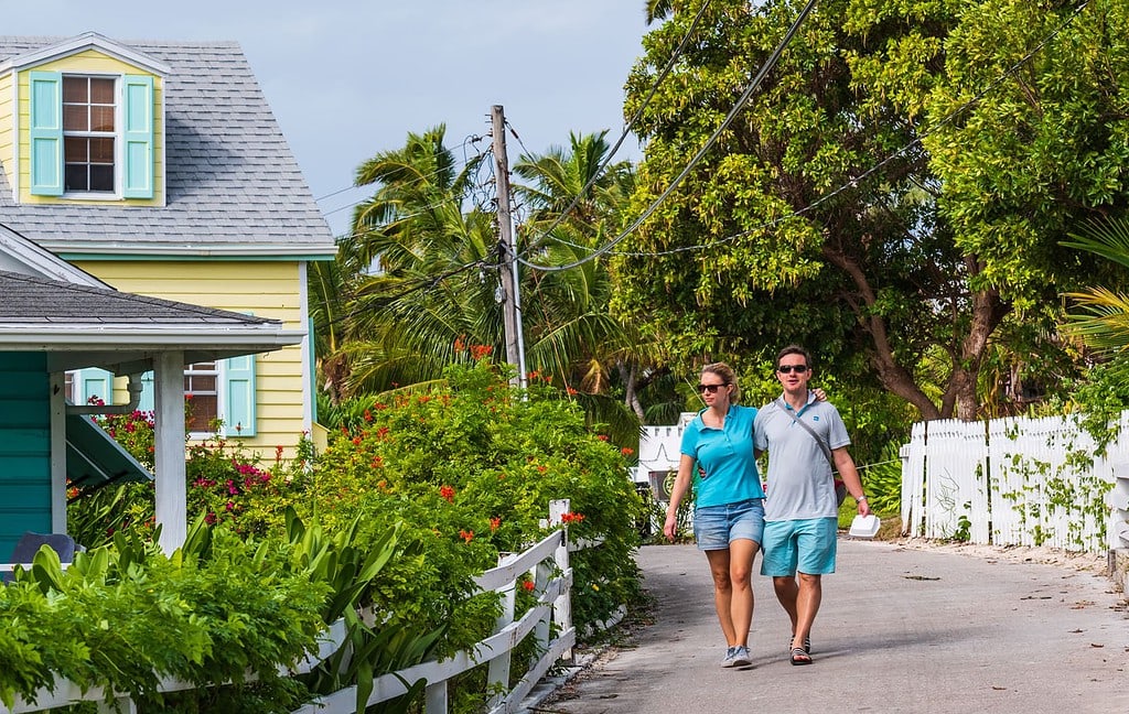Couple walks down road in Hope Town Bahamas