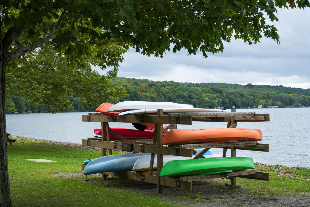 Kayaks on rack on Cayuga Lake shore at Taughannock Falls State Park.