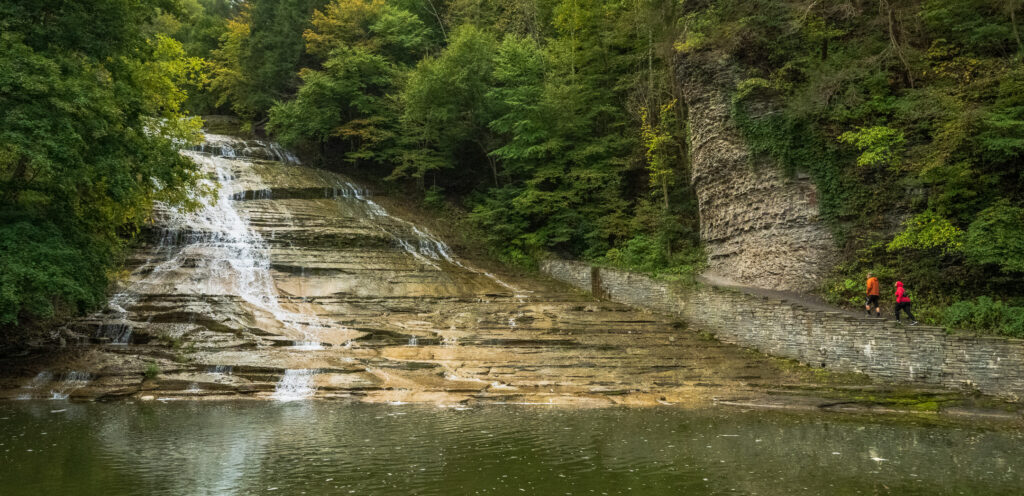 Couple climbs trail along Buttermilk Falls State Park in Ithaca NY