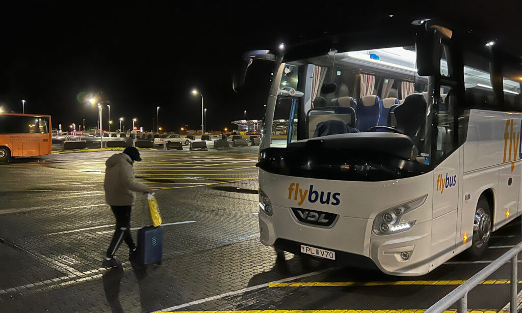 Flybus airport transfer bus awaits passengers in the early morning hours.