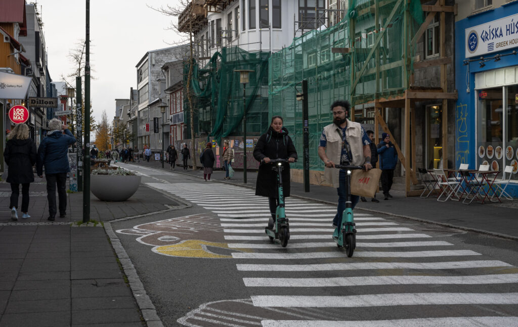 Couple rides scooter in Reykjavik
